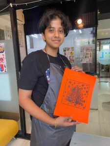 A girl is holding her sketch.