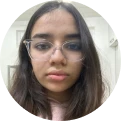 aarvi_sanghvi - We-Learn Art Classes - We-Learn Art Classes Portrait of a young woman with glasses looking at the camera indoors.