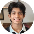 nevaan_doshi - We-Learn Art Classes - We-Learn Art Classes Young man with dark hair smiling at the camera, wearing a light blue shirt and blazer.